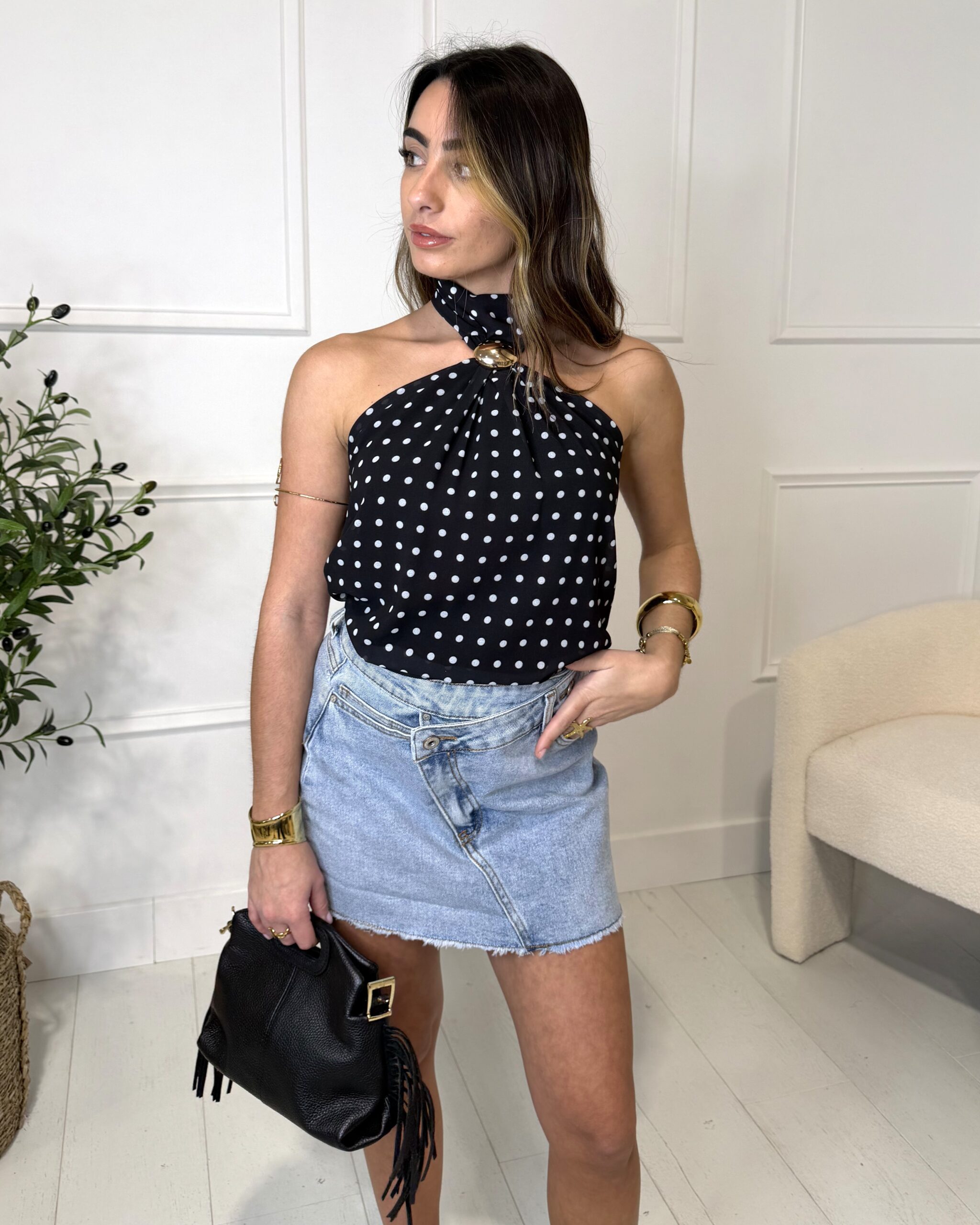 Top noir sans manches à pois avec col montant et bijou intégré